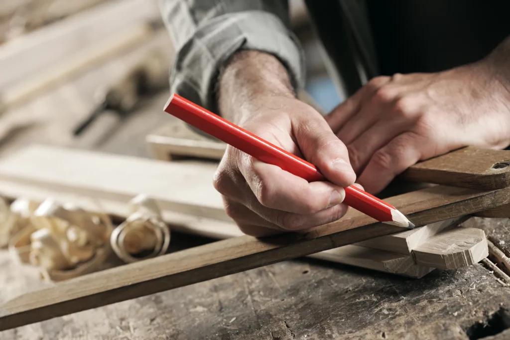 Menuisier traçant une coupe au crayon sur une planche